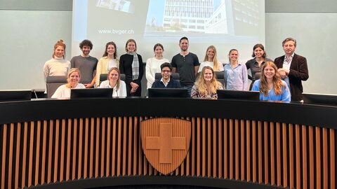 Das Gruppenfoto im Gerichtssaal ist ein gern gesehenes Erinnerungsstück an eine Besuchsführung am Bundesverwaltungsgericht. | © BVGer / TAF Das Bild zeigt eine Gruppe von 15 Besucherinnen und Besucher im Gerichtssaal des Bundesverwaltungsgerichts. | © BVGer / TAF